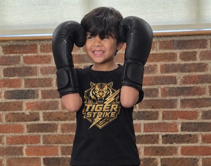 Young Tiger Strike student holding boxing gloves